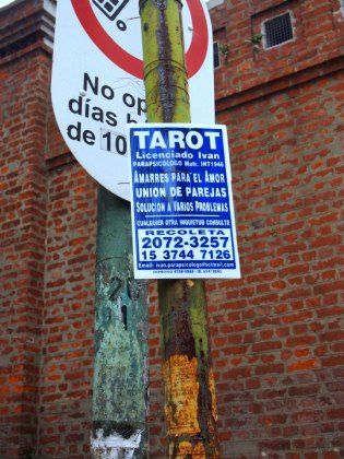 A tarot card reader's advert outside the cemetery walls.